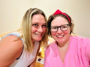Image of two women in a waiting room smiling.